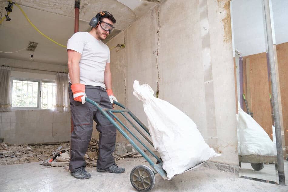 builder collecting construction debris in a bag a 2022 08 24 09 51 49 utc